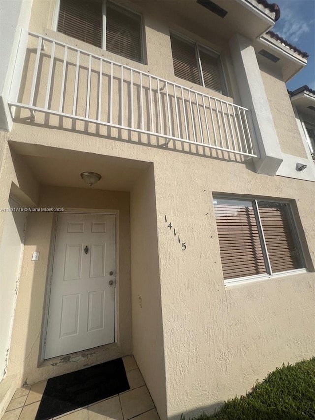 view of exterior entry featuring a balcony