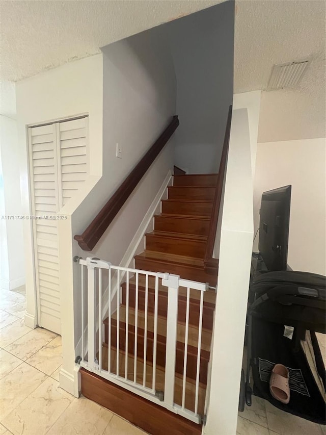 stairway with a textured ceiling