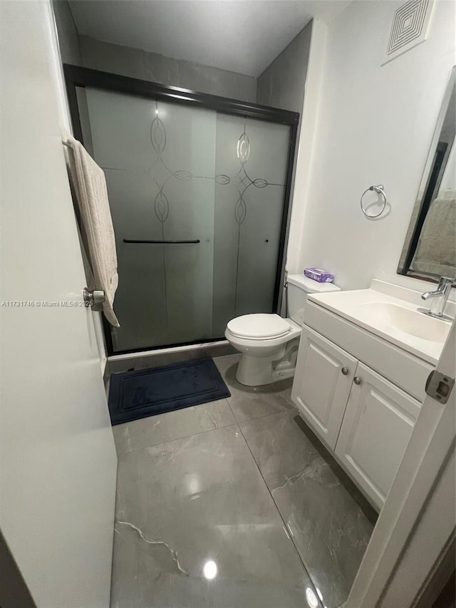 bathroom with walk in shower, vanity, and toilet