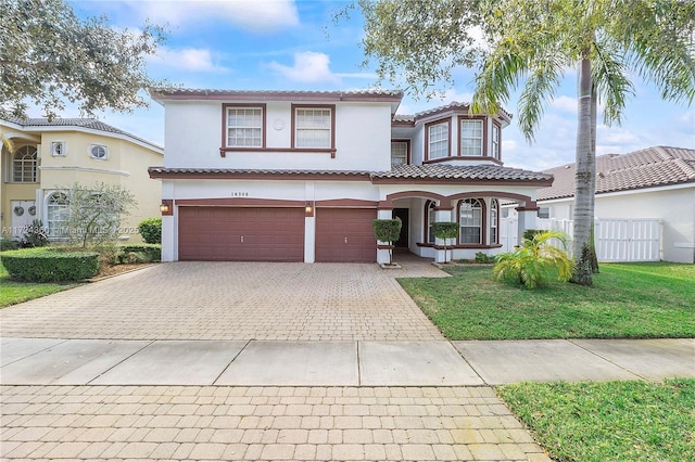 mediterranean / spanish-style house featuring a porch, a garage, and a front lawn