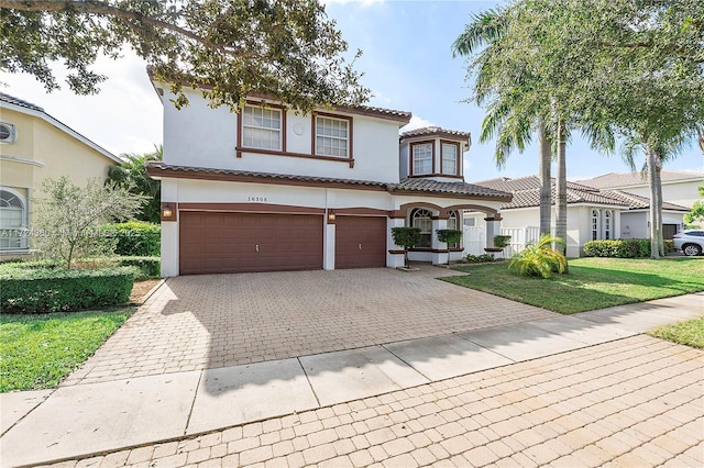 mediterranean / spanish home with a garage and a front yard