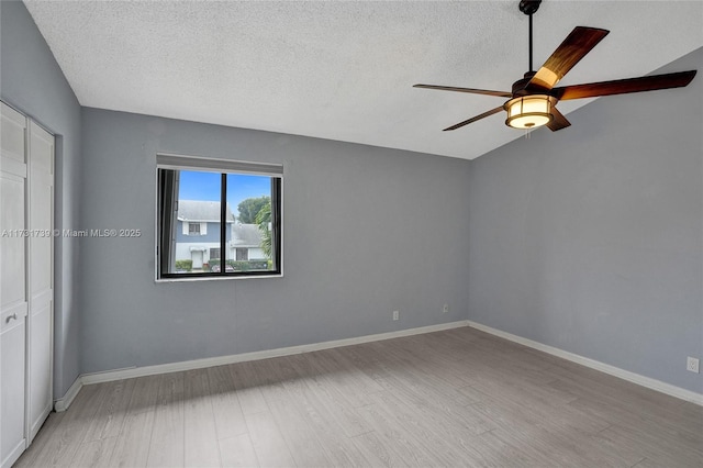 unfurnished room with ceiling fan, light hardwood / wood-style floors, and a textured ceiling