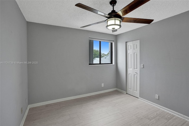 empty room featuring ceiling fan, a textured ceiling, and light hardwood / wood-style flooring