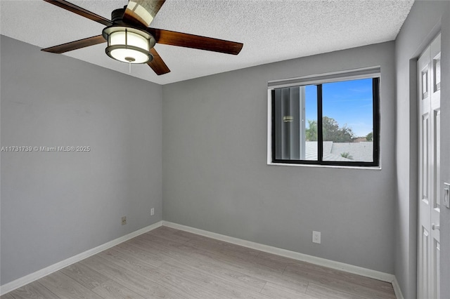 unfurnished room featuring ceiling fan, light hardwood / wood-style floors, and a textured ceiling