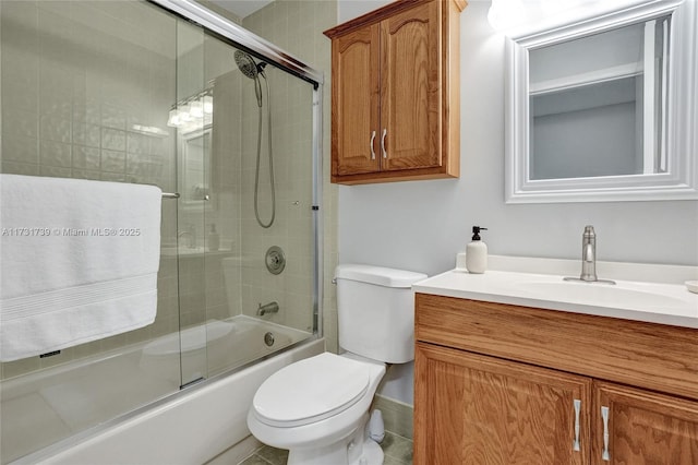 full bathroom featuring vanity, combined bath / shower with glass door, and toilet