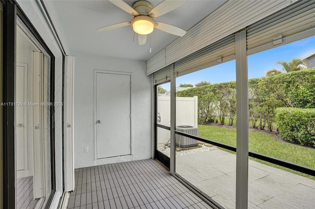 unfurnished sunroom featuring ceiling fan