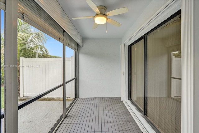 unfurnished sunroom featuring ceiling fan