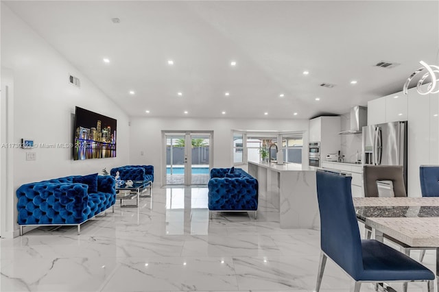 living room with lofted ceiling and french doors