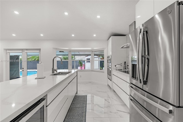 kitchen featuring sink, white cabinets, beverage cooler, stainless steel appliances, and french doors