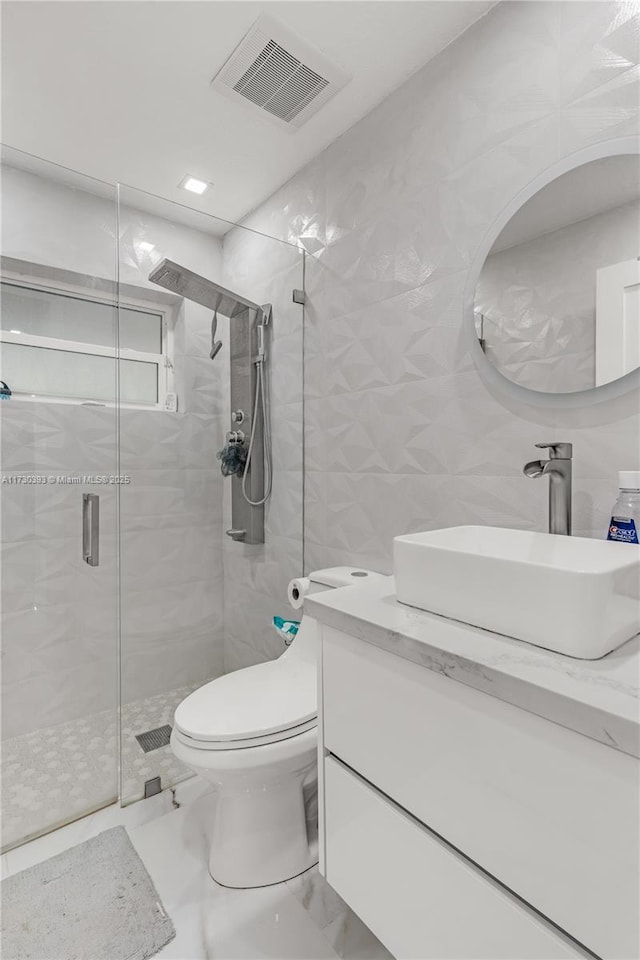 bathroom with vanity, an enclosed shower, tile walls, and toilet