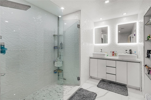 bathroom with vanity, a textured ceiling, and walk in shower