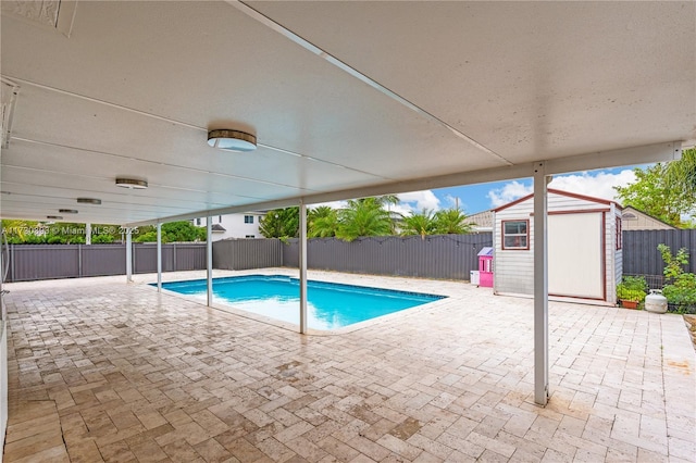 view of swimming pool with a patio and a shed