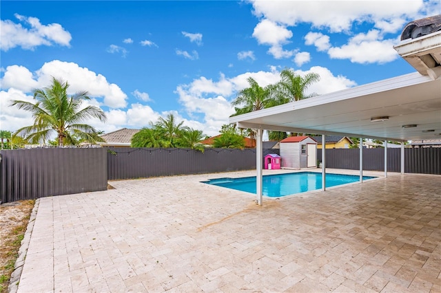 view of swimming pool with a storage unit and a patio area