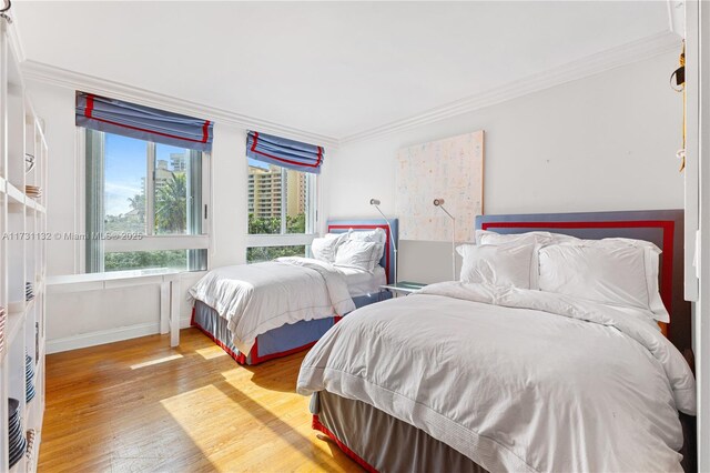 bedroom with crown molding and light hardwood / wood-style floors