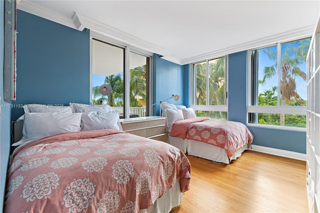 bedroom featuring multiple windows, crown molding, and hardwood / wood-style flooring