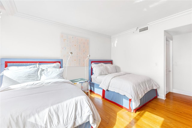 bedroom with hardwood / wood-style flooring and crown molding