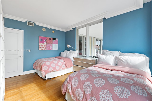 bedroom featuring hardwood / wood-style flooring and ornamental molding