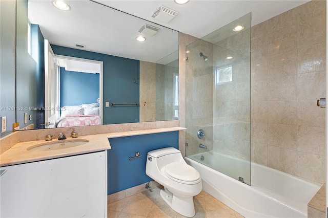 full bathroom with tile patterned flooring, vanity, tiled shower / bath combo, and toilet