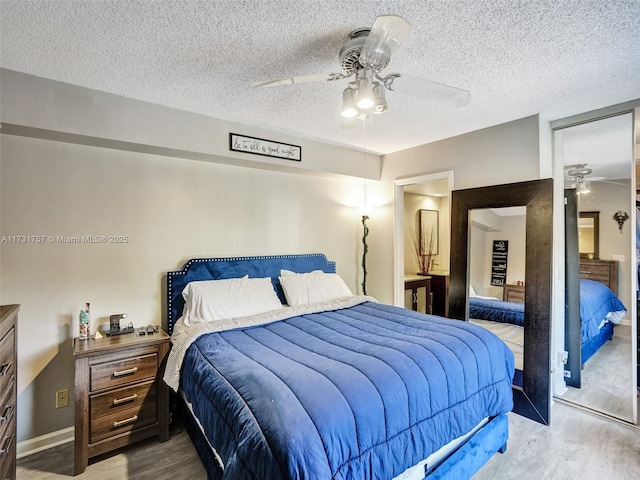 bedroom featuring a textured ceiling, light hardwood / wood-style flooring, a closet, and ceiling fan