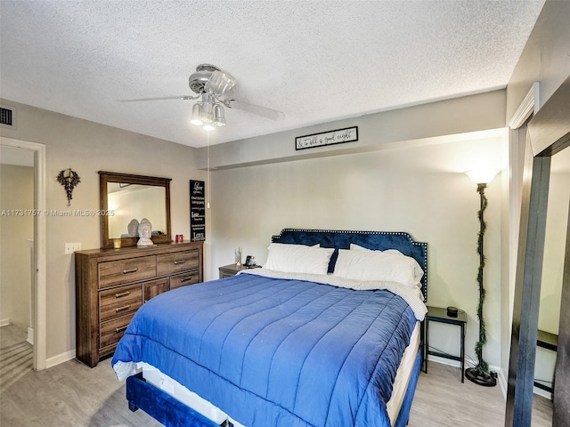 bedroom with ceiling fan and a textured ceiling