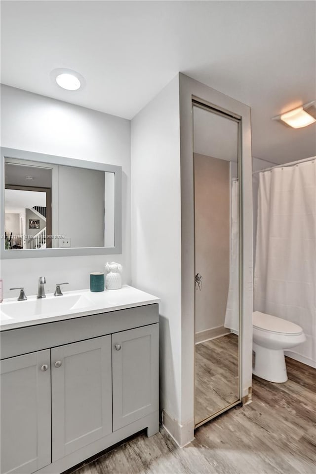 bathroom with vanity, wood-type flooring, and toilet