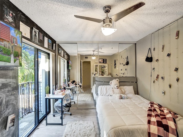 bedroom with access to exterior, hardwood / wood-style floors, and ceiling fan