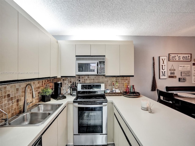 kitchen with tasteful backsplash, sink, a textured ceiling, and appliances with stainless steel finishes