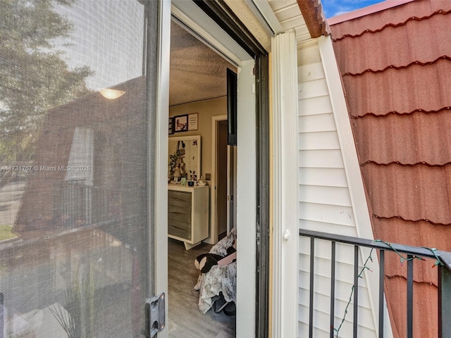 view of exterior entry with a balcony