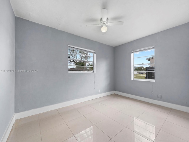 tiled spare room featuring ceiling fan and a healthy amount of sunlight