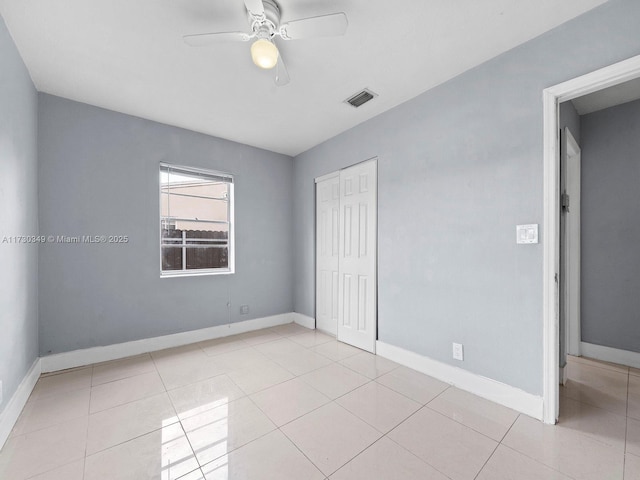 unfurnished bedroom featuring light tile patterned flooring, ceiling fan, and a closet