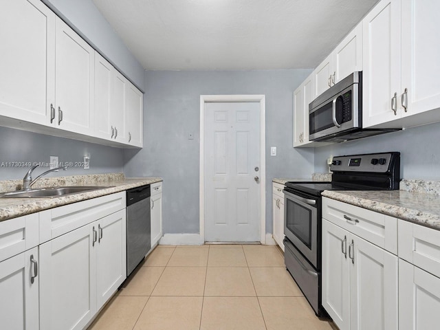 kitchen featuring light tile patterned floors, stainless steel appliances, sink, and white cabinets