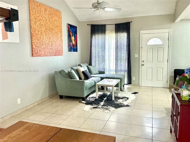 living room with light tile patterned floors, ceiling fan, lofted ceiling, and baseboards