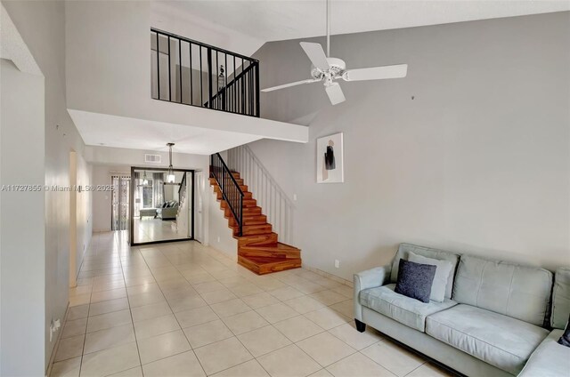 living room with light tile patterned floors, a textured ceiling, vaulted ceiling, and ceiling fan