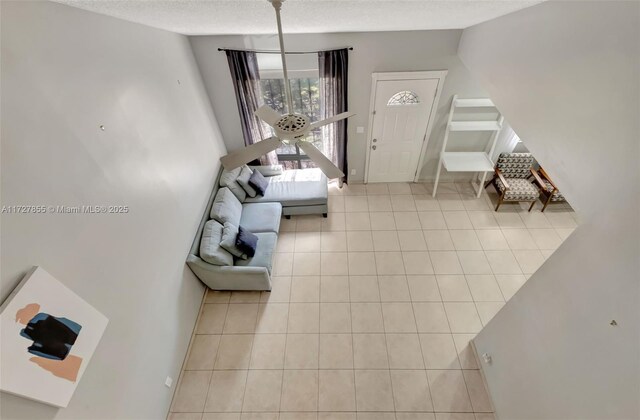 dining area featuring light tile patterned floors, vaulted ceiling, a textured ceiling, and ceiling fan