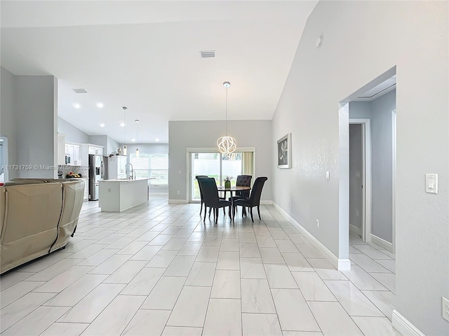 dining space featuring washer / clothes dryer, a chandelier, sink, and light tile patterned floors