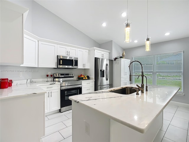 kitchen featuring appliances with stainless steel finishes, an island with sink, sink, white cabinets, and hanging light fixtures