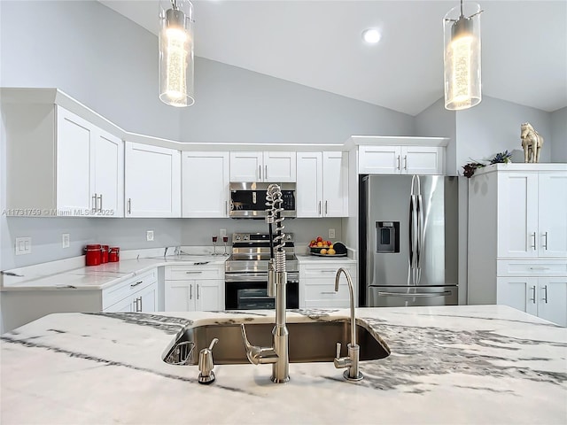 kitchen with stainless steel appliances, vaulted ceiling, pendant lighting, and white cabinets