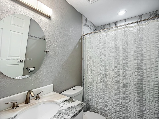 bathroom with vanity, a shower with shower curtain, and toilet