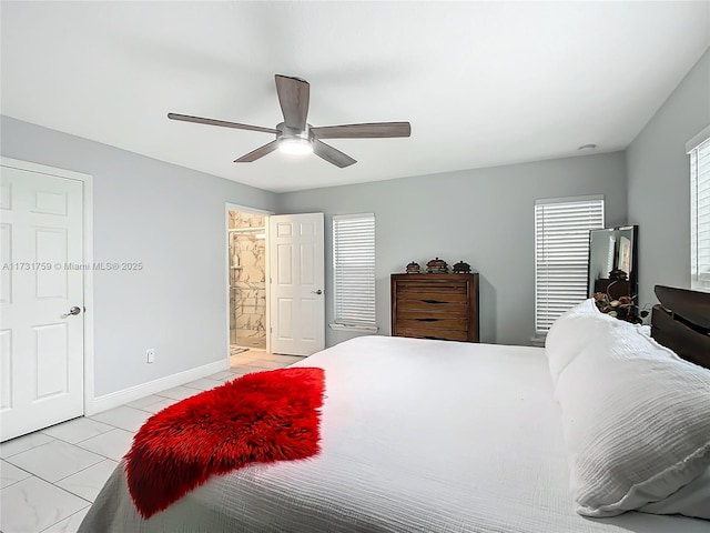 tiled bedroom featuring ceiling fan and ensuite bath