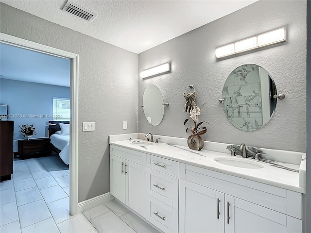 bathroom featuring vanity, tile patterned flooring, and a textured ceiling