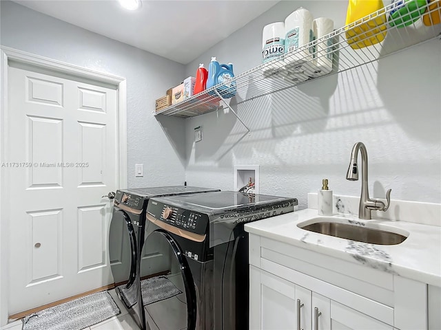 laundry room featuring separate washer and dryer, sink, and cabinets