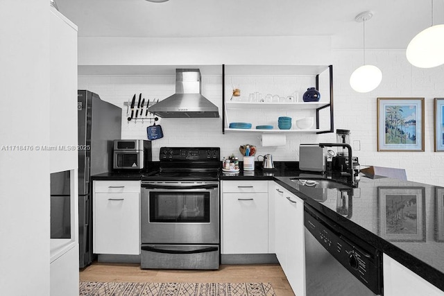 kitchen featuring sink, stainless steel appliances, white cabinets, decorative light fixtures, and wall chimney exhaust hood