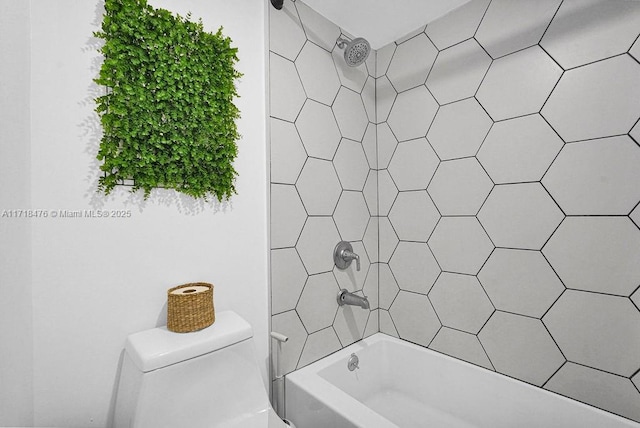 bathroom featuring tiled shower / bath and toilet