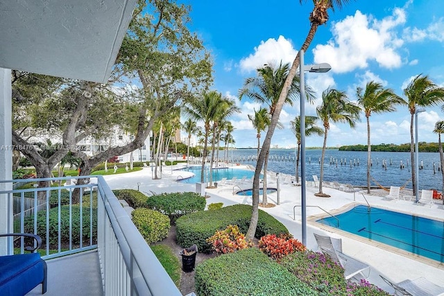 exterior space with a hot tub and a water view