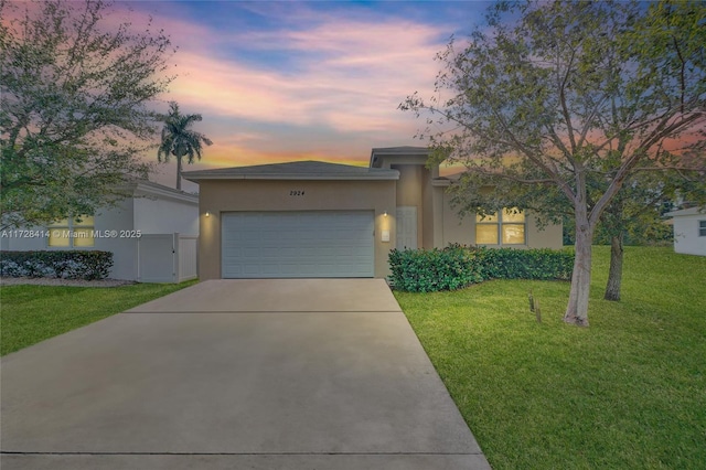 view of front facade with a garage and a lawn