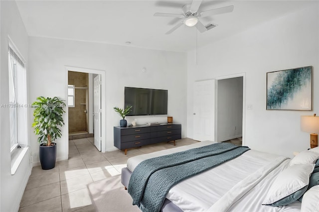 bedroom with ceiling fan, light tile patterned floors, and ensuite bath