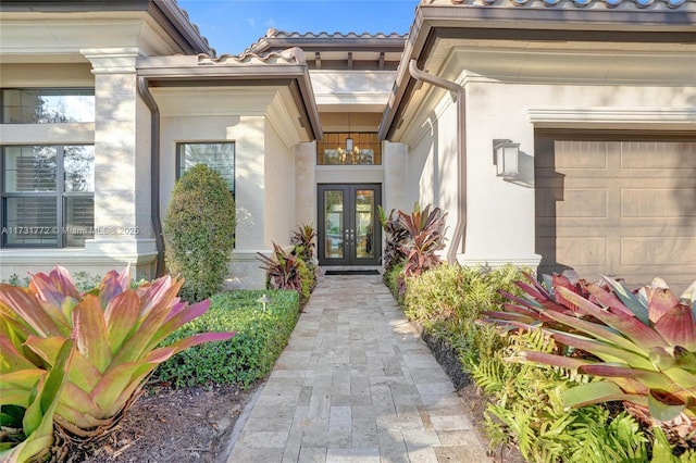 view of exterior entry with french doors and a garage