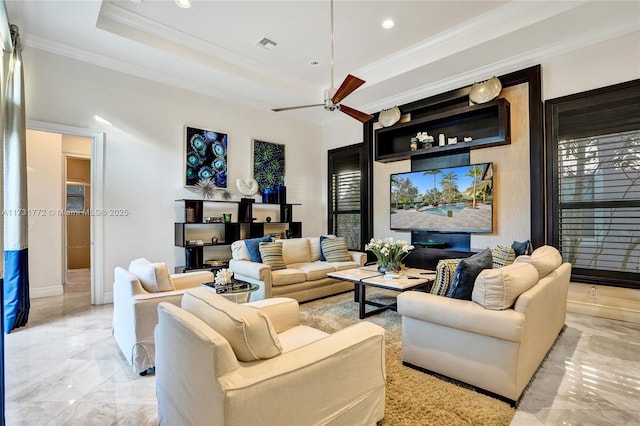 living room featuring crown molding, a raised ceiling, and ceiling fan