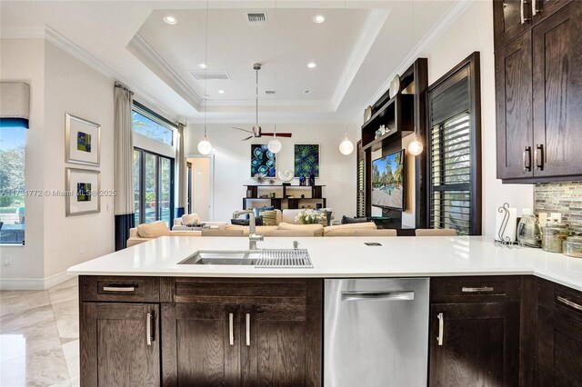 kitchen featuring pendant lighting, sink, dishwasher, ornamental molding, and a raised ceiling