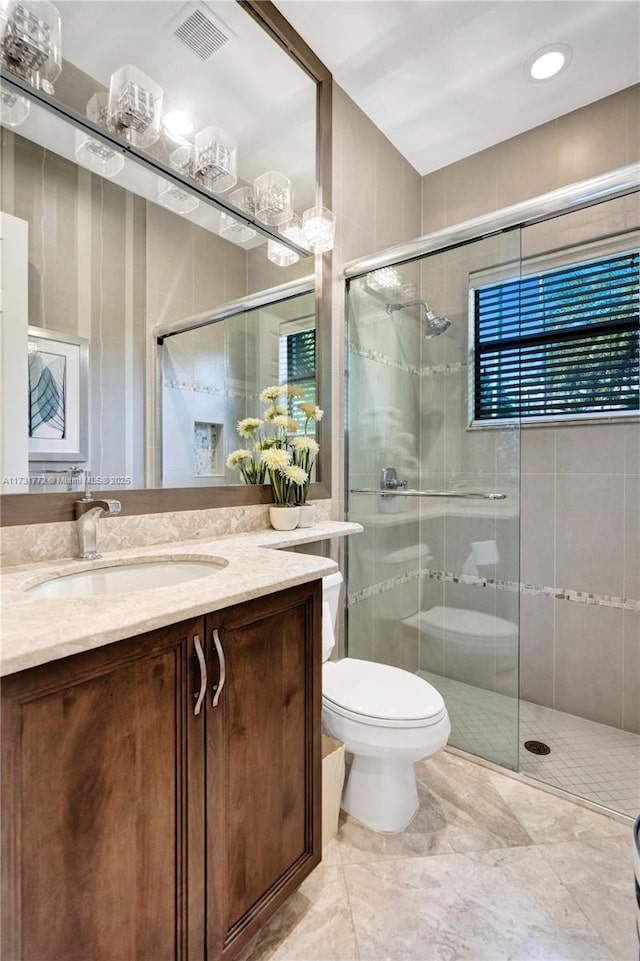 bathroom featuring vanity, toilet, and an enclosed shower